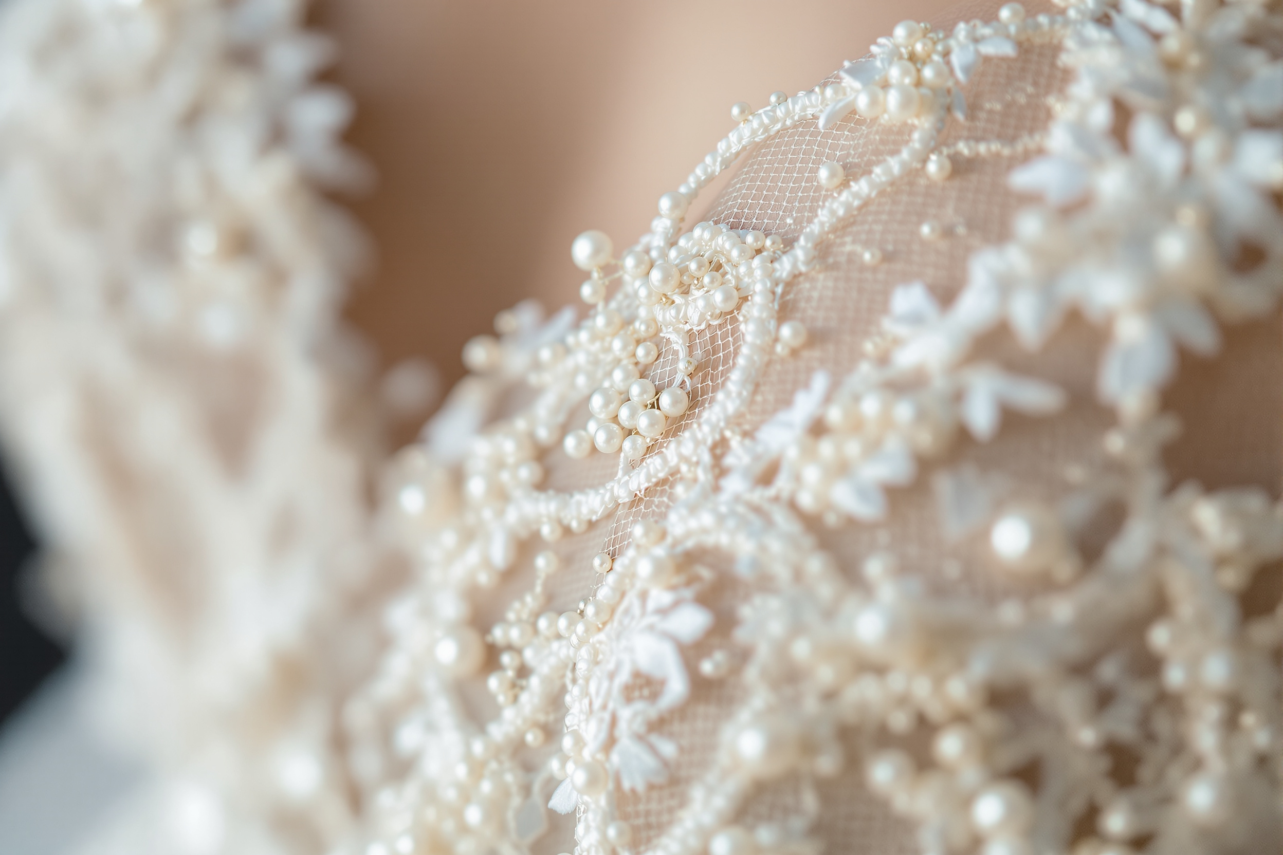Close-up detail of beaded French lace on an ivory wedding dress bodice